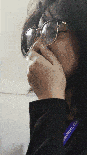 a woman wearing glasses and a lanyard with the word memorial on it