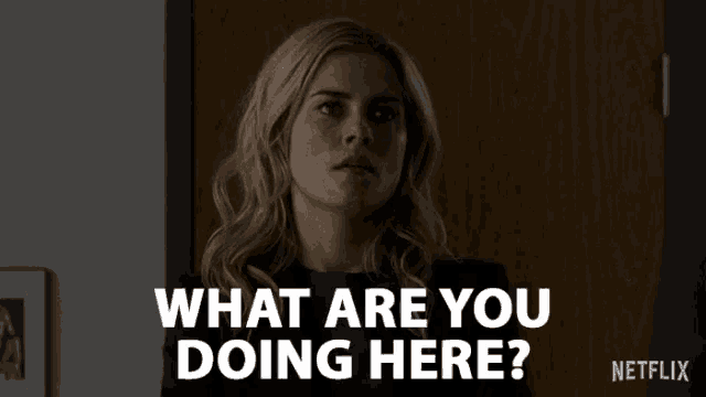 a woman is standing in front of a door and says what are you doing here