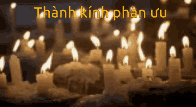 a bunch of lit candles in a dark room with the words thanh kinh phân ưu in yellow