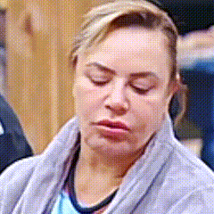 a woman with her eyes closed is wearing a grey sweater .