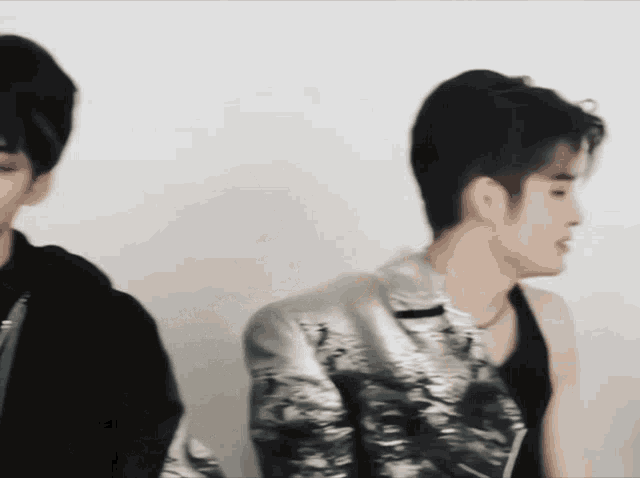 a man in a silver jacket is standing next to another man