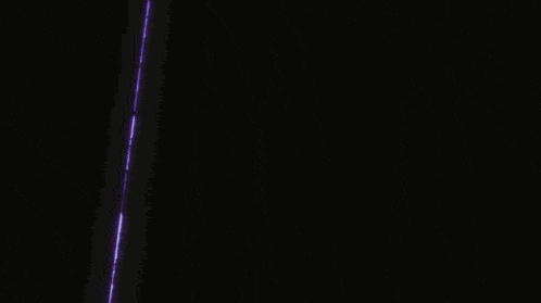 a purple light is coming out of a dark room through a doorway .