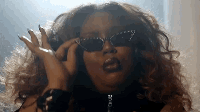 a close up of a woman wearing sunglasses and a black jacket