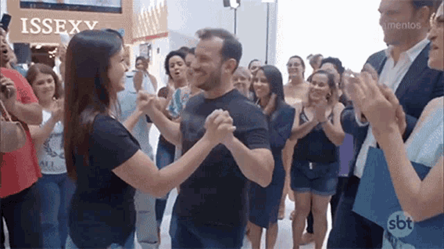 a group of people are dancing in front of a sign that says issex