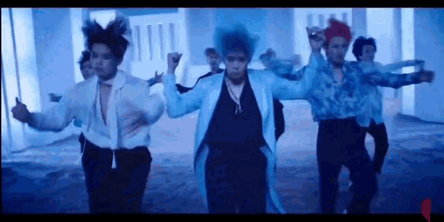 a group of men are dancing together in a dark room in front of a building .