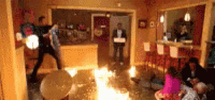 a group of people are in a living room with a fire coming out of the floor .