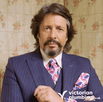 a man in a suit and tie with victorian plumbing.co.uk on the bottom