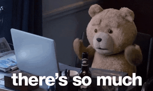 a teddy bear is sitting at a desk in front of a laptop with the words there 's so much below it