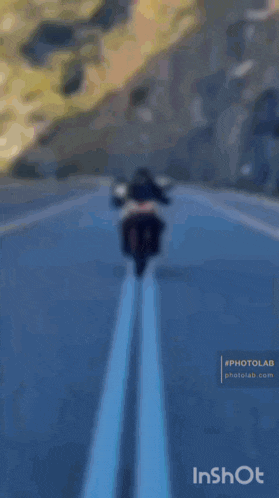 a man is riding a motorcycle on a road with the words pcfr ub inshot below him