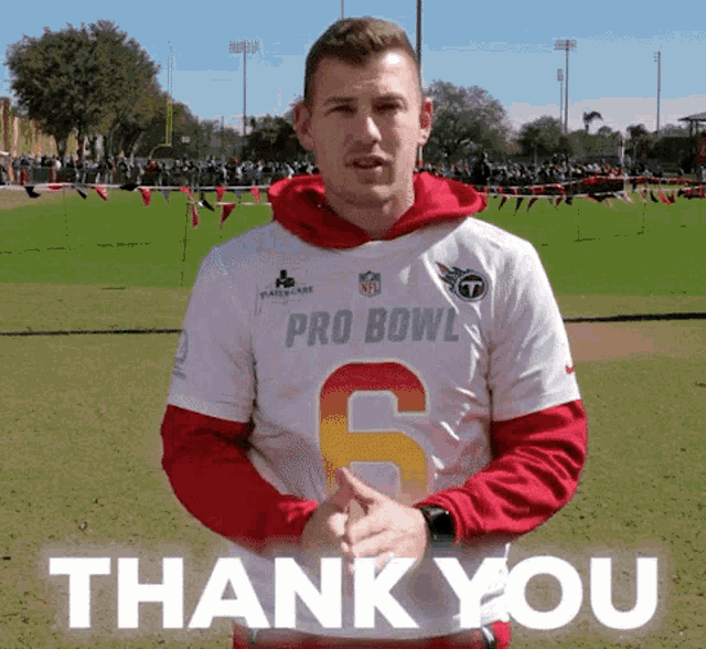 a man wearing a pro bowl 6 jersey is giving a thank you gesture