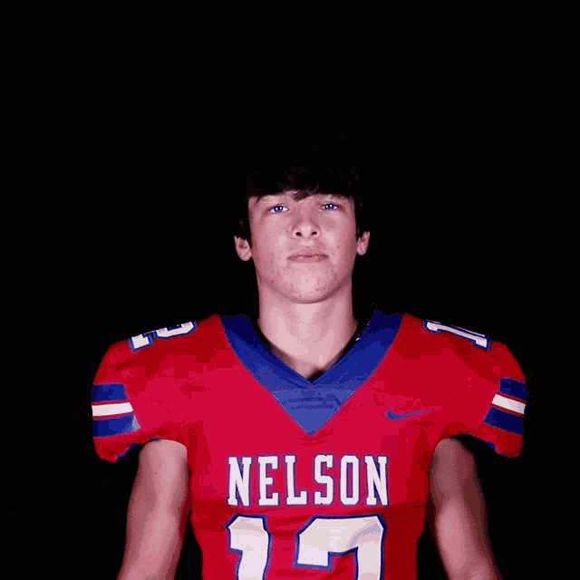 a young man wearing a red nelson jersey