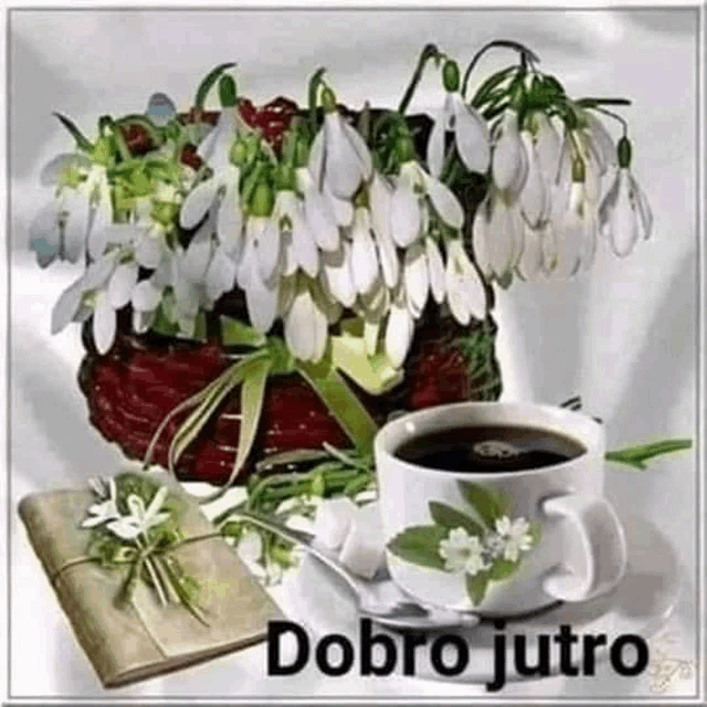 a cup of coffee is sitting on a saucer next to a vase of snowdrop flowers .