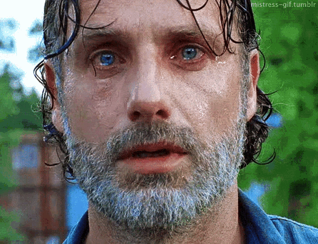 a man with a beard and blue eyes is sweating .