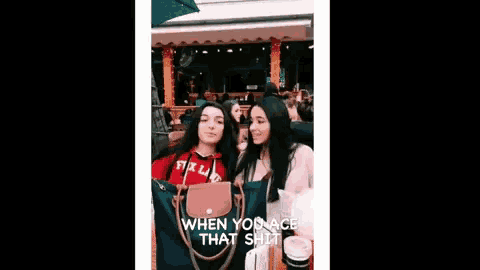 two girls are standing next to each other with their arms in the air and a purse .