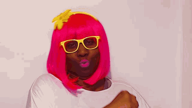 a woman wearing a pink wig and glasses is making a funny face
