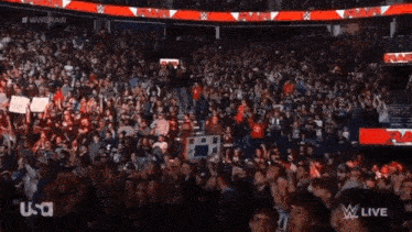 a crowd of people watching a wrestling show with the word raw on the jumbo tron