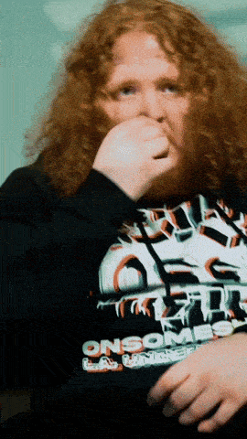 a man with red curly hair is wearing a black shirt that says onsome