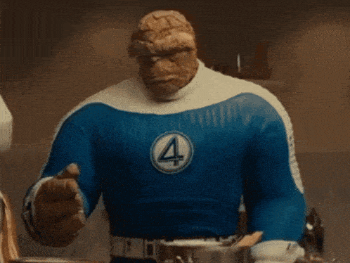 a close up of a person in a superhero costume with a rock face and a blue shirt .