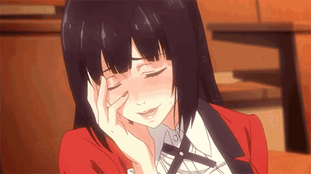 a girl in a red jacket is covering her eyes with her hand .
