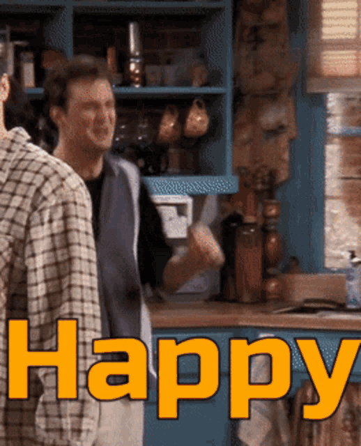 two men standing in a kitchen with the word happy written in orange