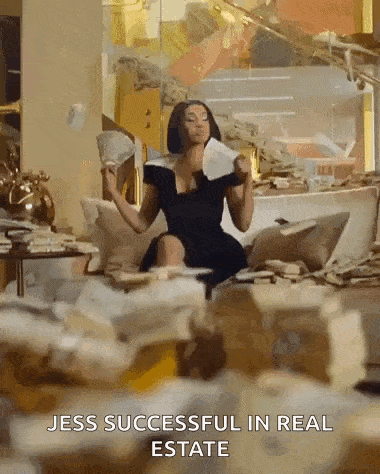 a woman in a black dress is sitting on a couch with a fan in her hand and a pile of money .