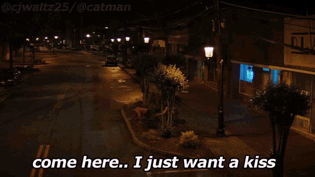 a couple sitting on the side of a street with the words come here i just want a kiss below them