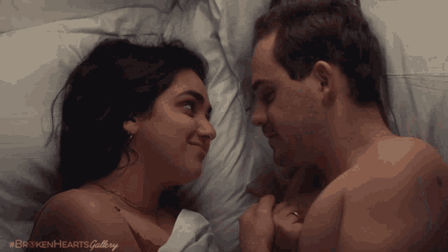 a man and a woman laying in bed looking at each other with the caption #brokenheartsgallery