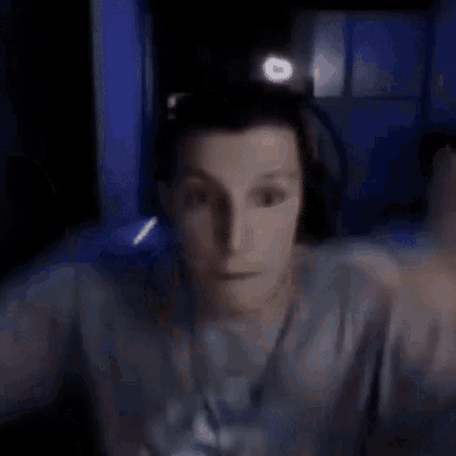 a close up of a person making a funny face with their hands on their head .