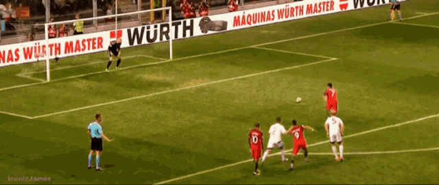 a group of soccer players are playing on a field with a wurth banner behind them
