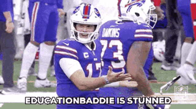 a couple of football players hugging each other on a field with the words `` education baddie is stunned '' .
