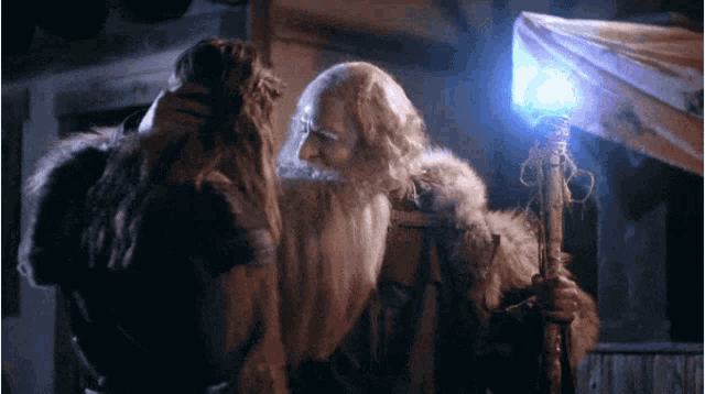 a man with a beard is holding a glowing stick