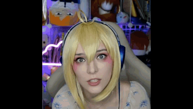a woman wearing a wig and headphones is making a funny face while sitting in a chair .