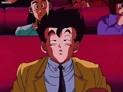 a man in a suit and tie is sitting in a movie theater .