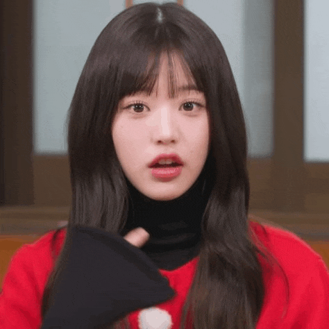 a close up of a young woman wearing a red sweater and black turtleneck .