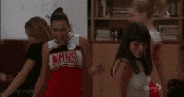 a cheerleader wearing a wmhs uniform is dancing with other cheerleaders .