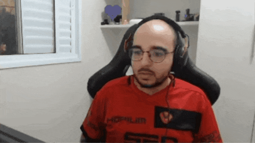 a bald man wearing glasses and headphones is wearing a red shirt that says hopilin