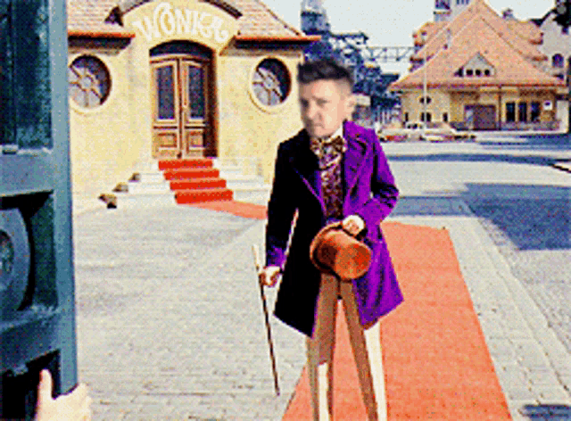 a boy in a purple suit is standing in front of a building that says wonkee