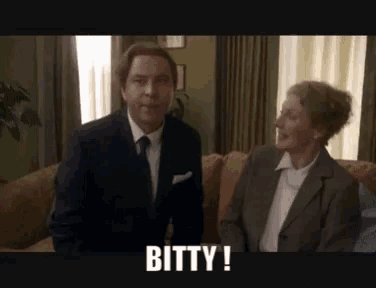 a man in a suit and tie is sitting next to an older woman who is smiling and says bitty
