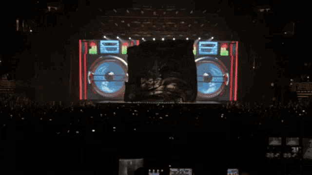 a crowd of people are watching a concert with a large screen behind them that says boombox