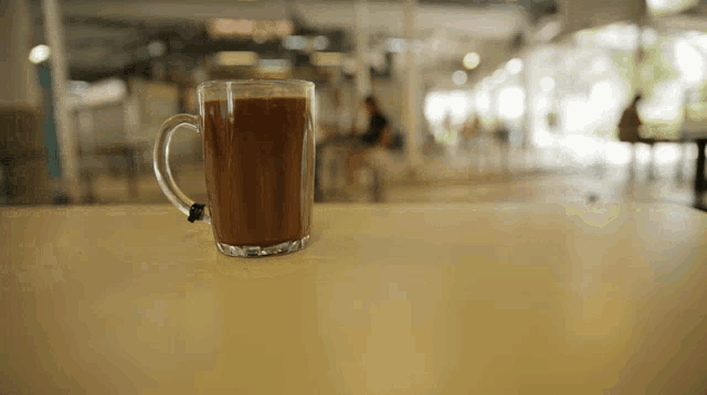 a cup of coffee sits on a table in a cafe