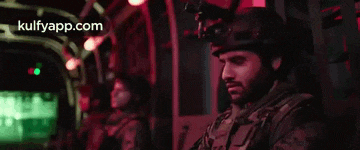 a man in a helmet is standing in a dark room with the words kulfyapp.com in the corner .