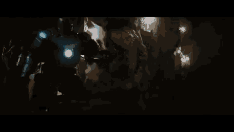 a person is sitting in a dark room with a blue light behind them