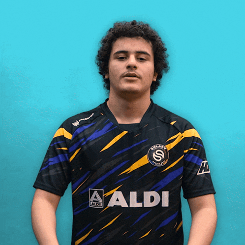 a man wearing a black and yellow shirt that says aldi on the front