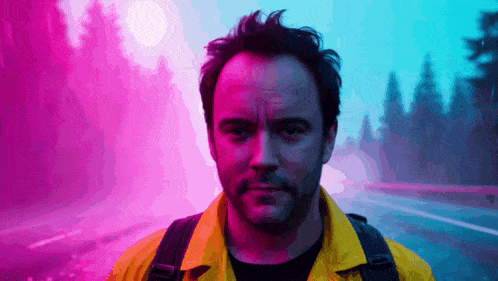 a man in a yellow jacket is standing in front of a purple and blue background