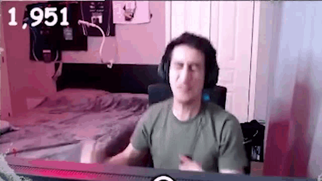 a man wearing headphones is sitting at a desk in front of a computer monitor .