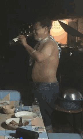 a man without a shirt is pouring a bottle of wine