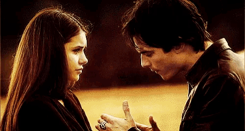 a man and a woman are looking at each other and the man is wearing a ring on his finger