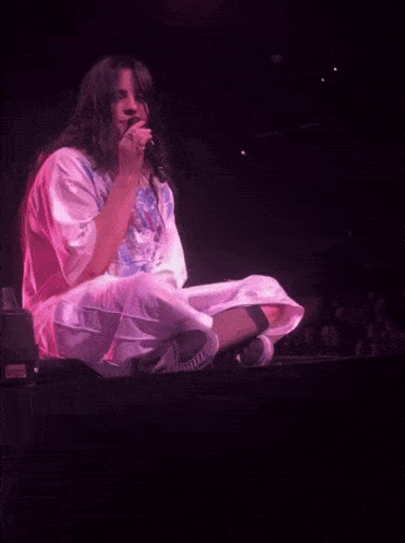 a woman sitting on a stage with a microphone