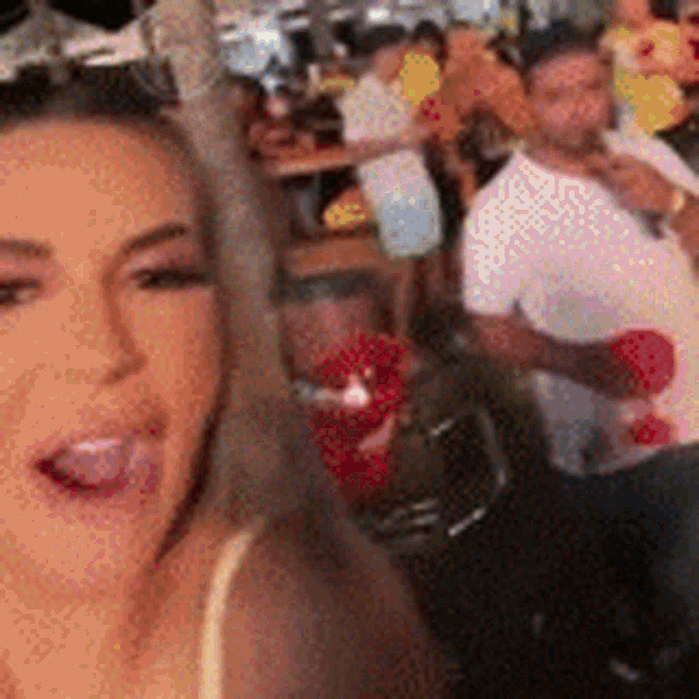 a woman is sticking her tongue out in front of a crowd .