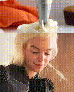 a woman is decorating a cupcake with frosting